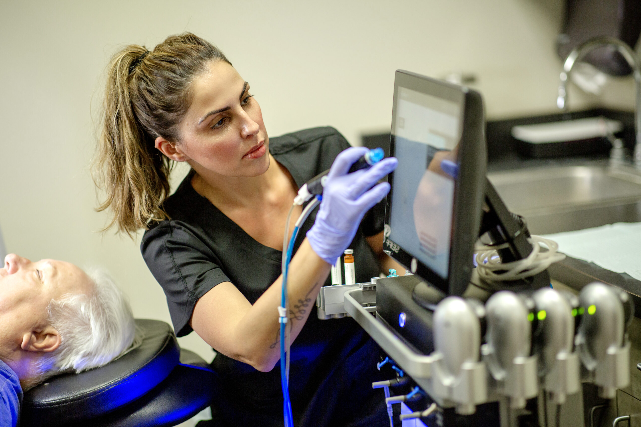 a woman in a black shirt and gloves working on a computer